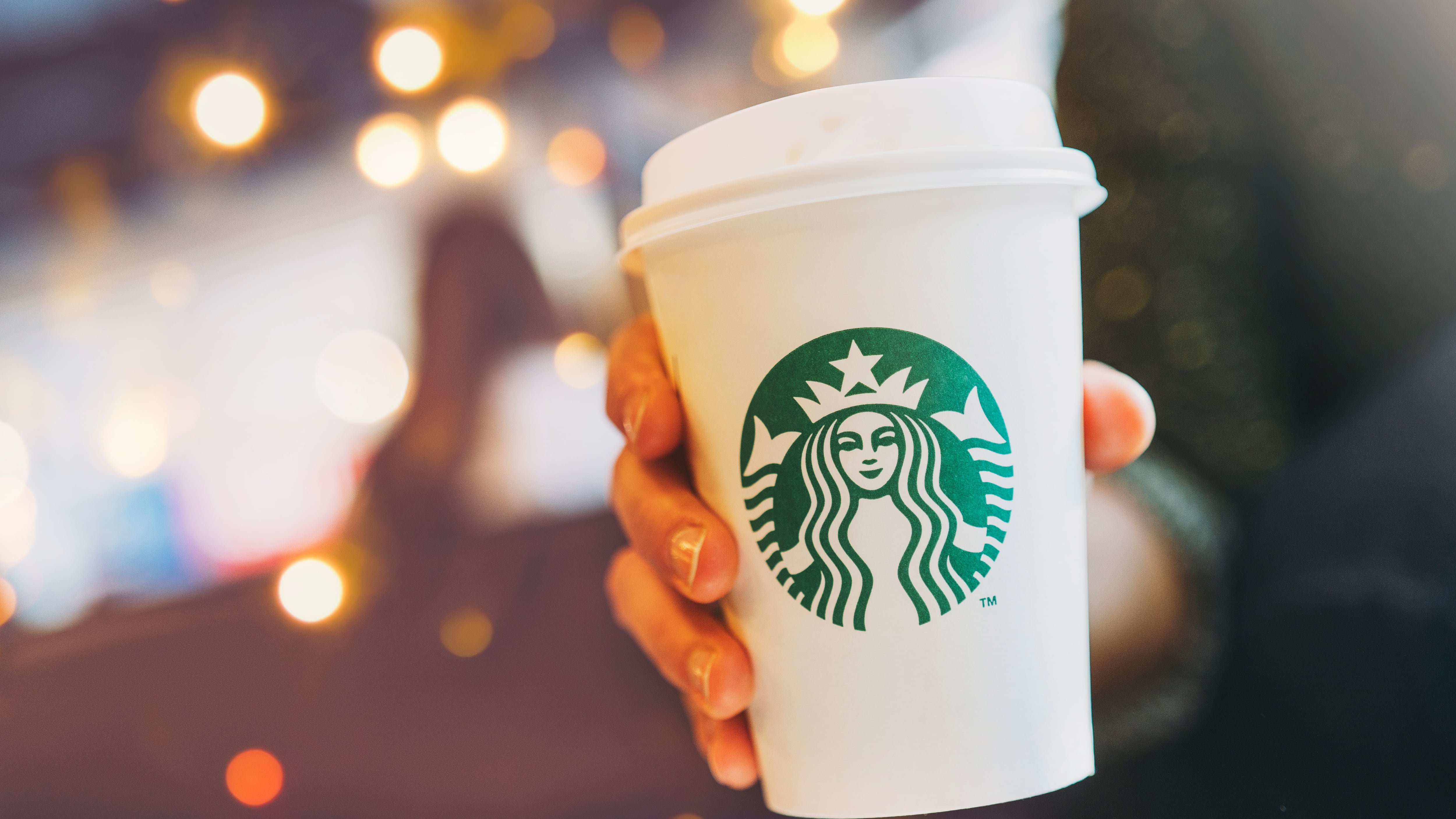 Close up of a Woman drinking a tall Starbucks coffee in Starbucks coffee shop